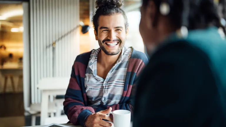Image montrant une personne qui prends son café avec un sourire (pause)